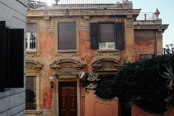 Chic townhouse exterior with warm cream facade and bronze details under soft afternoon light.