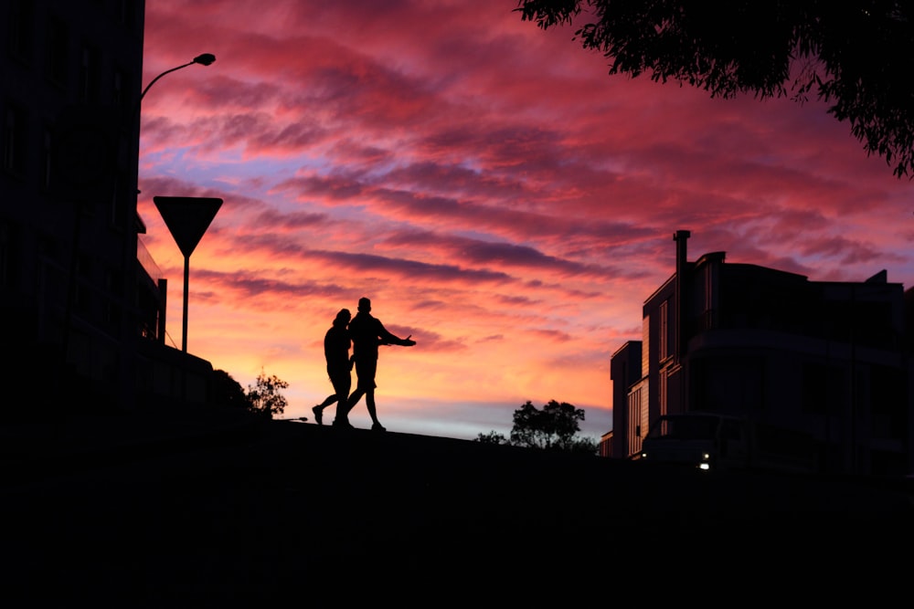 two persons walking near building