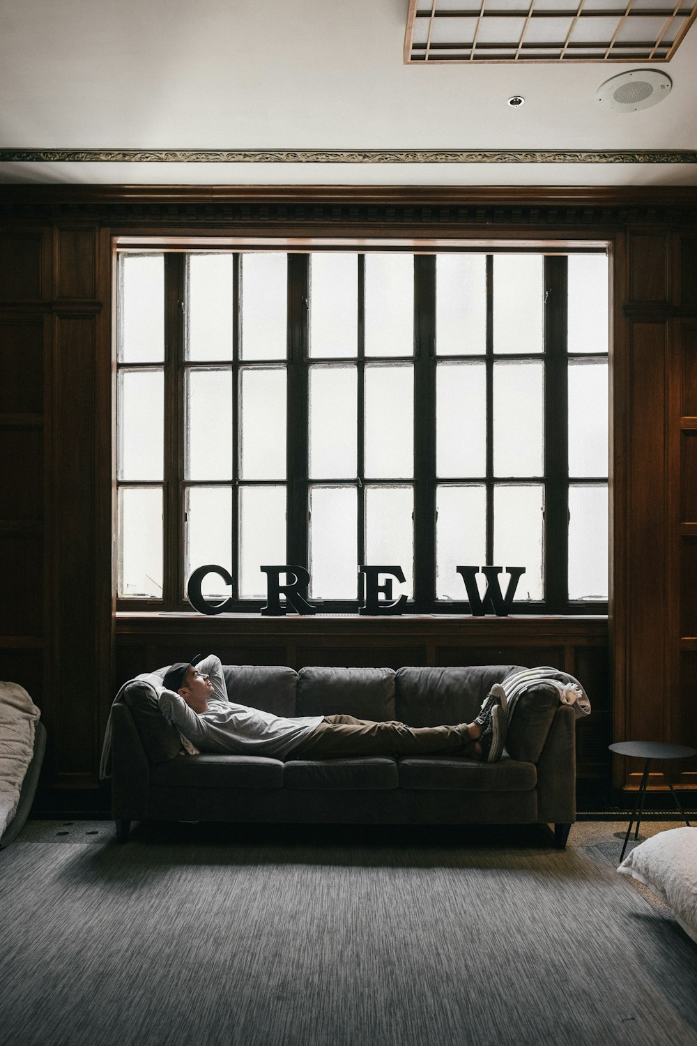 Foto einer Person, die auf dem Sofa in der Nähe des Fensters liegt