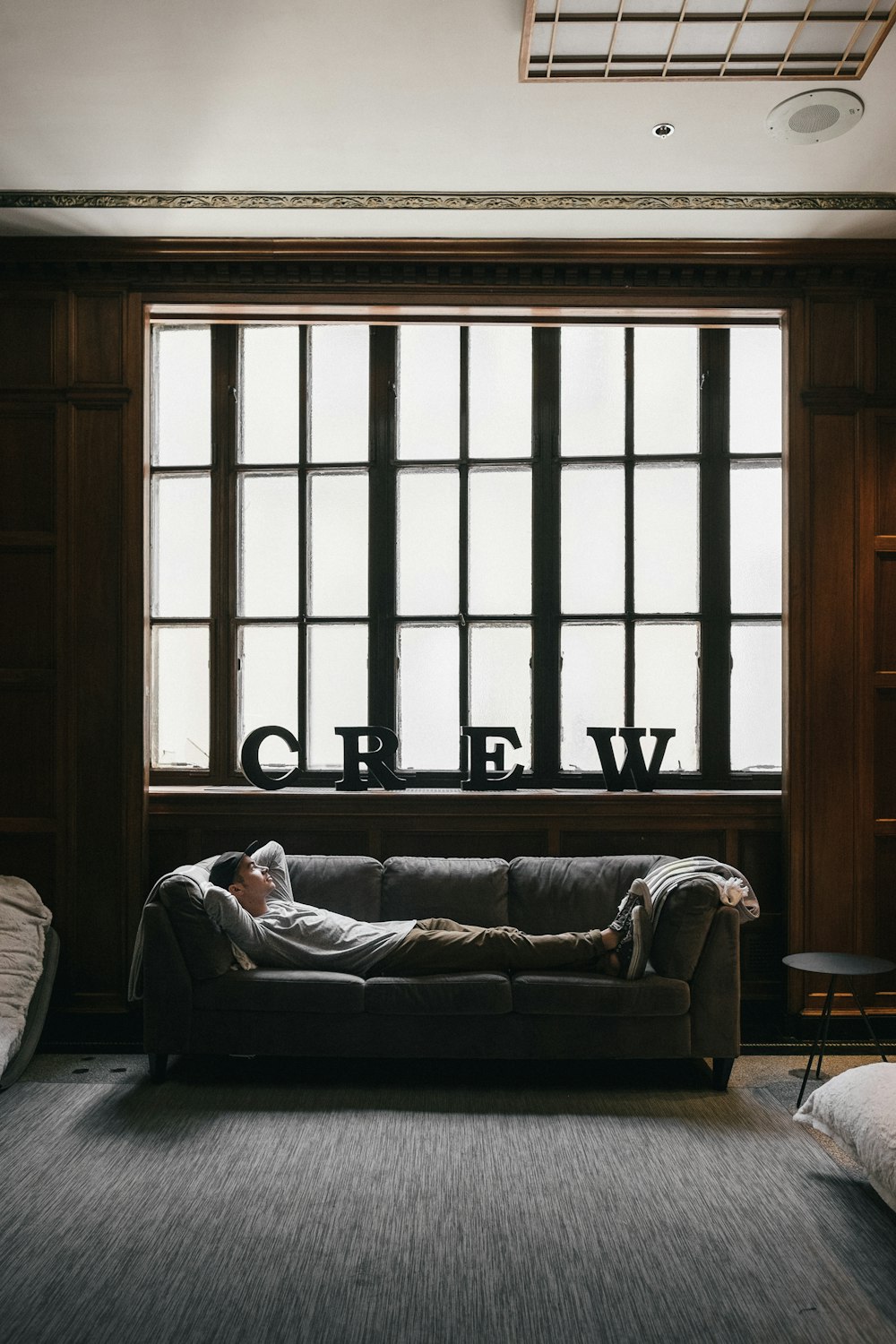 photo of person laying on sofa near window
