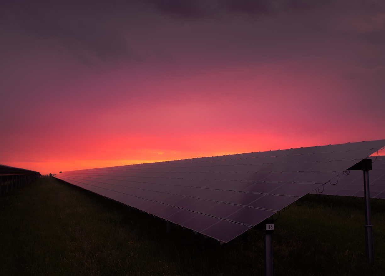 black solar panel under red and gray clouds