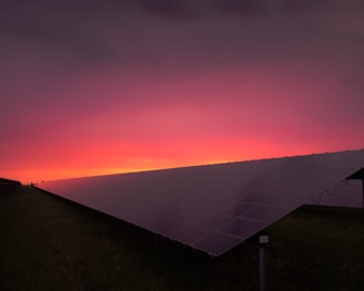 black solar panel under red and gray clouds