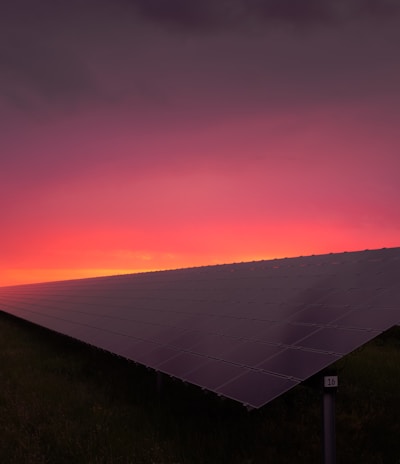 black solar panel under red and gray clouds