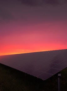 black solar panel under red and gray clouds