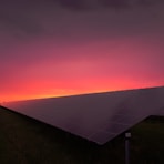 black solar panel under red and gray clouds