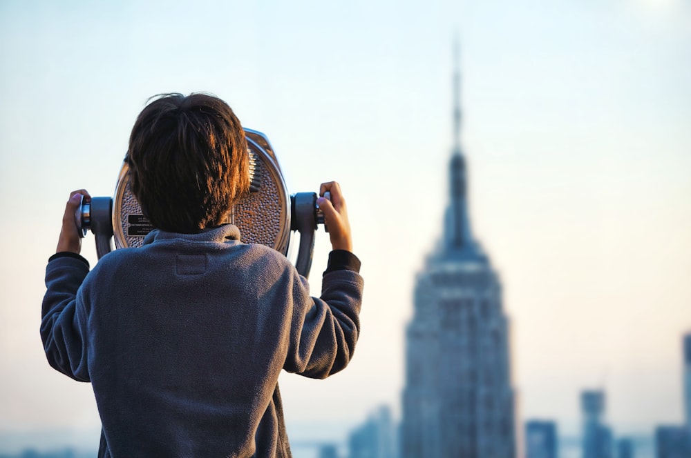 타워 뷰어를 통해 엠파이어 스테이트 빌딩을 보고 있는 아이