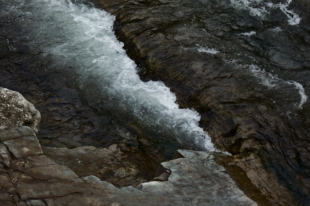 bird's eye view of water crashing boulders