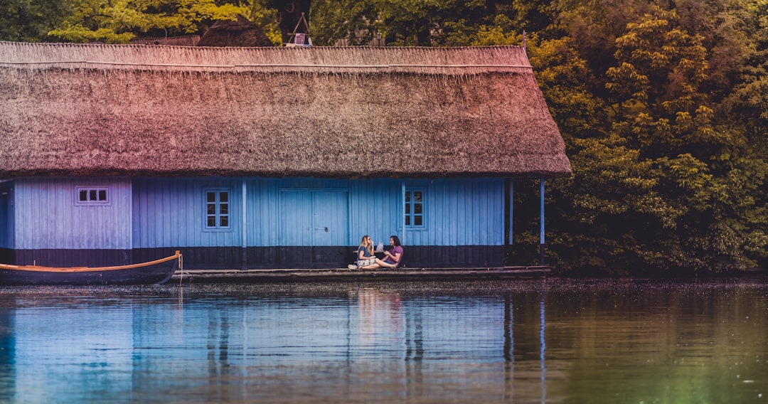 two person sitting on bench near body of water