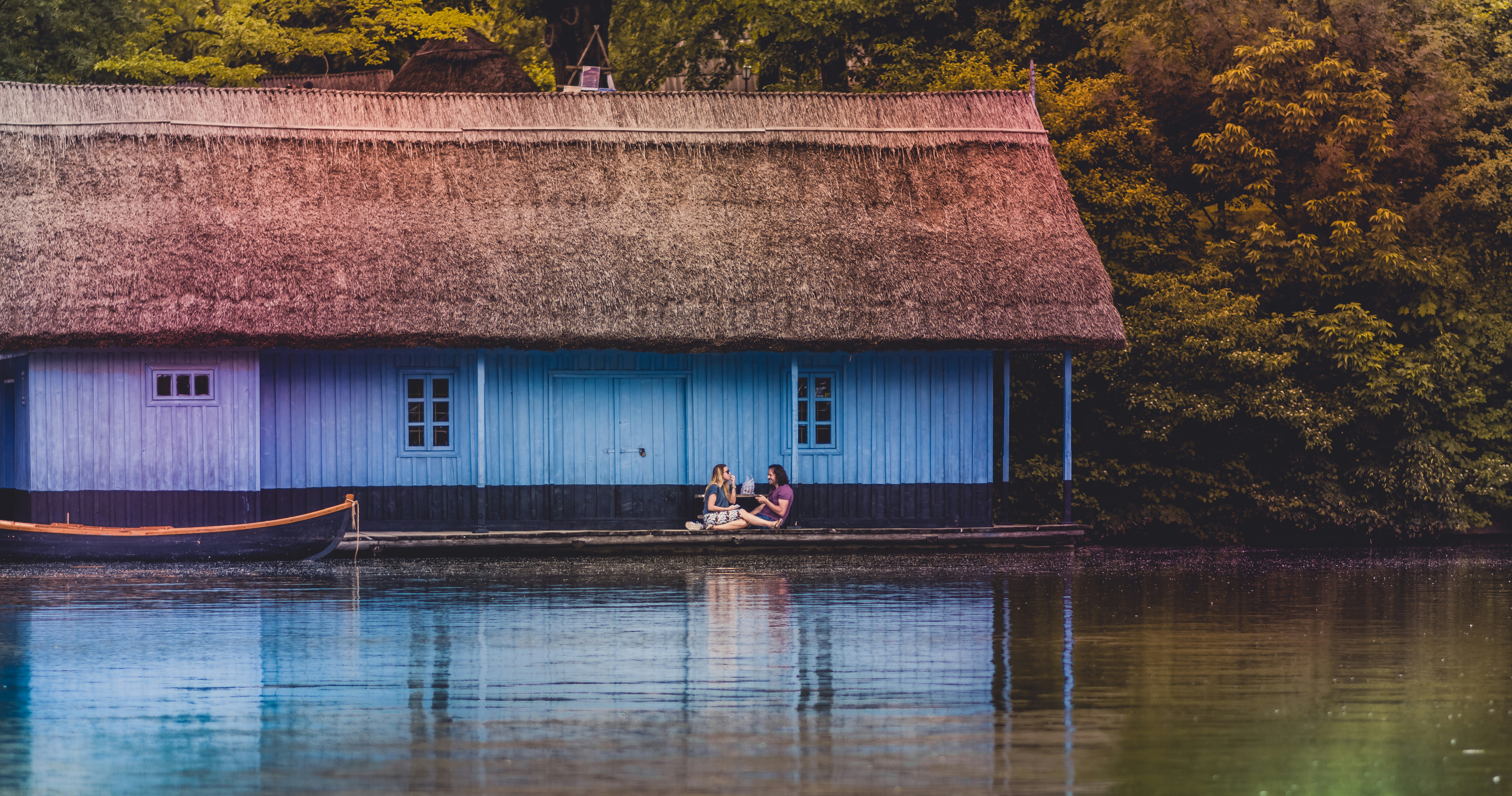 two person sitting on bench near body of water