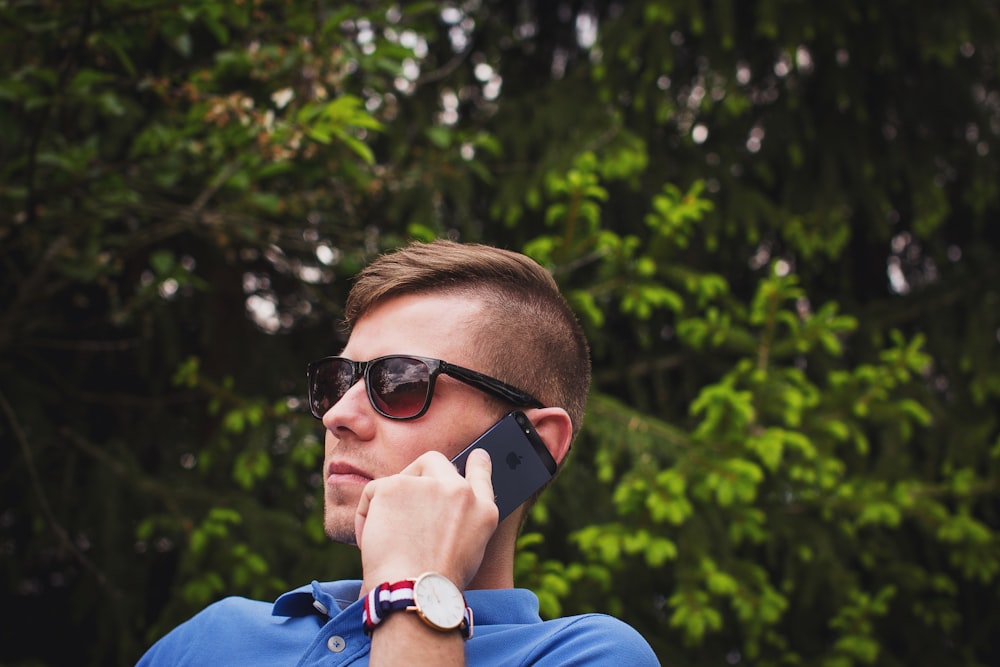 person holding Android smartphone wearing black sunglasses