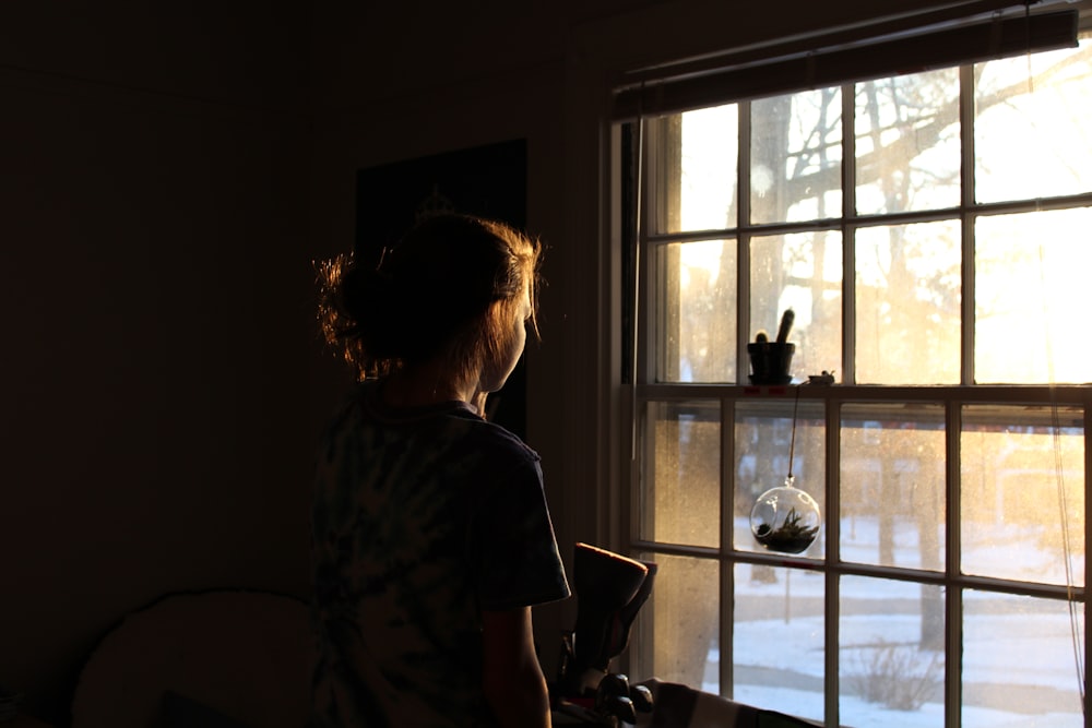 Mujer en la ventana de la habitación que da a la ventana