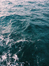 A swirling blend of lemon green, sea blue, and deep blue waves in motion.