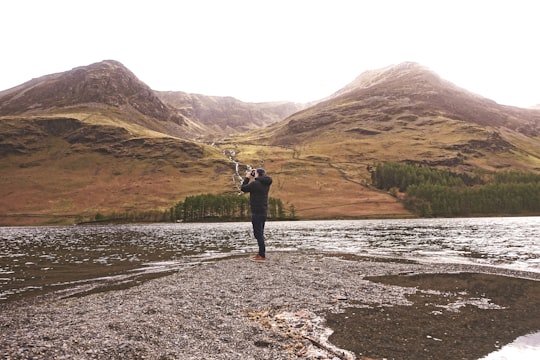 person taking photo of mountain in Lake District National Park United Kingdom