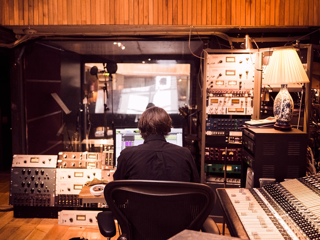 man in front of studio mixer and receiver, Mixing session
