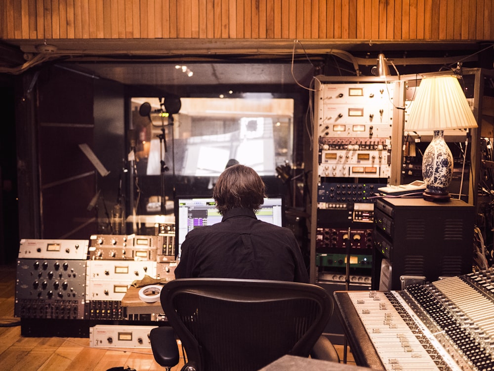 man in front of studio mixer and receiver