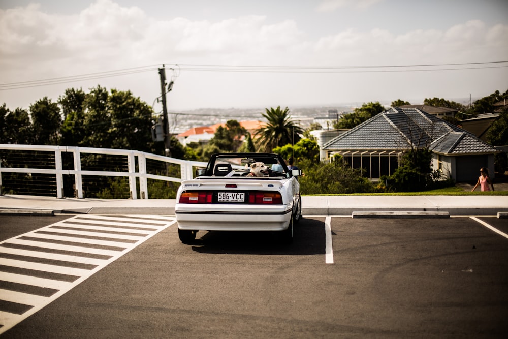 white convertible beside pedestrian lane