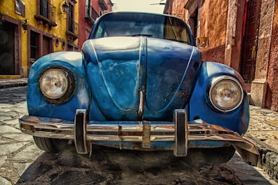 blue vehicle parked near building at daytime