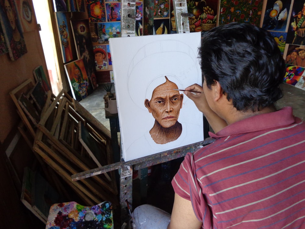 Un hombre haciendo un retrato de otra persona.