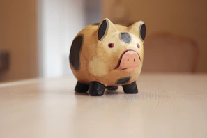 Creative personal piggy banks painted with joyful colors and unique names on a minimalist white table