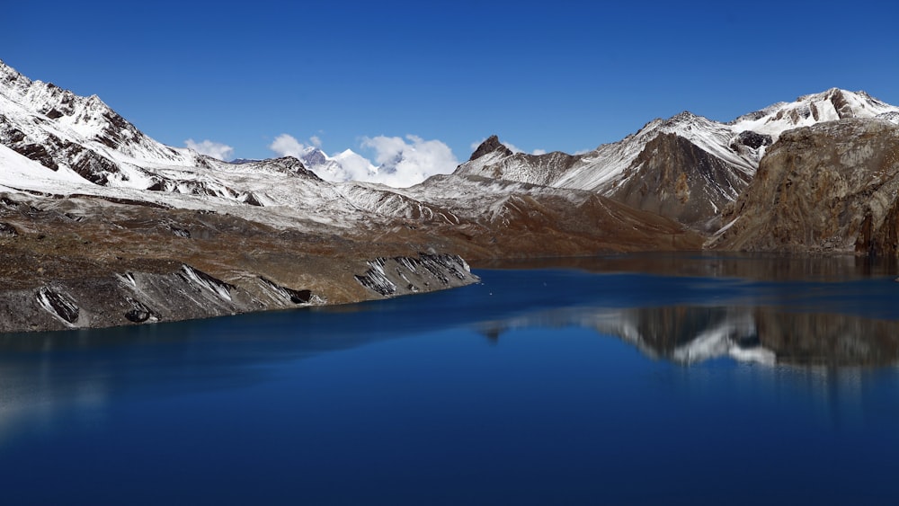 snow coated mountain beside body of water