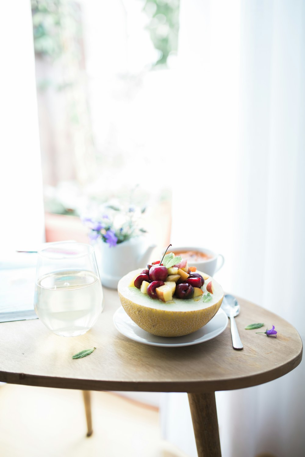 dessert dish filled white plate beside spoon