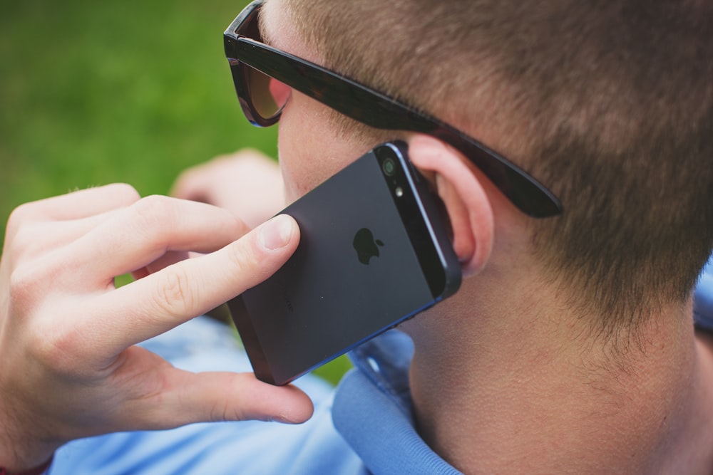 person holding black iPhone 5s