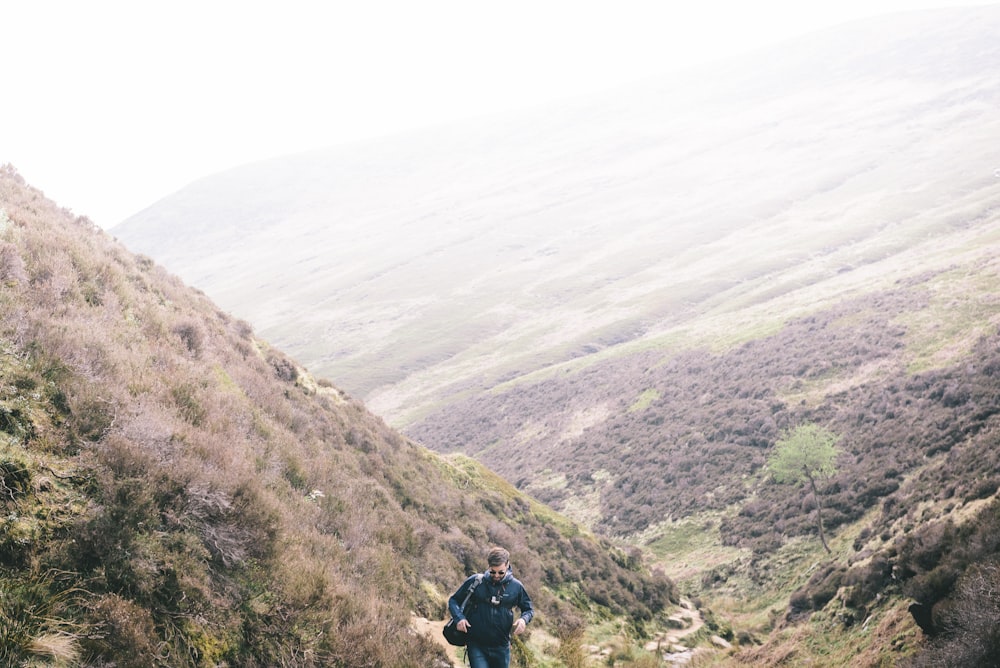 man walking on mountain during daytime