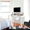 white wooden desk near bed inside the room