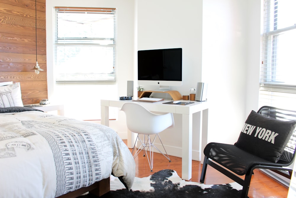 white wooden desk near bed inside the room