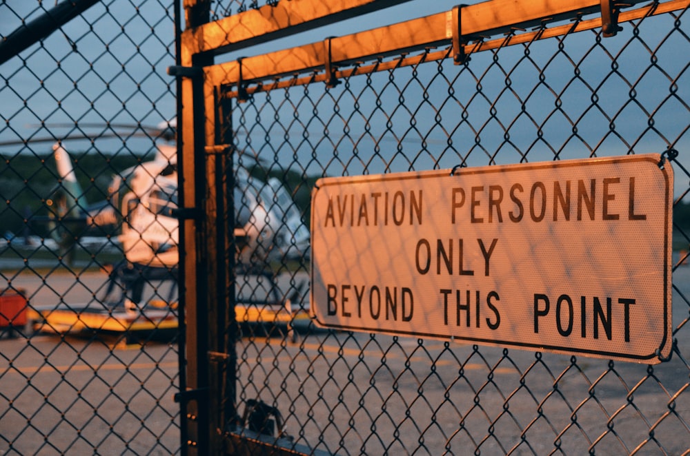 a sign is posted on a chain link fence