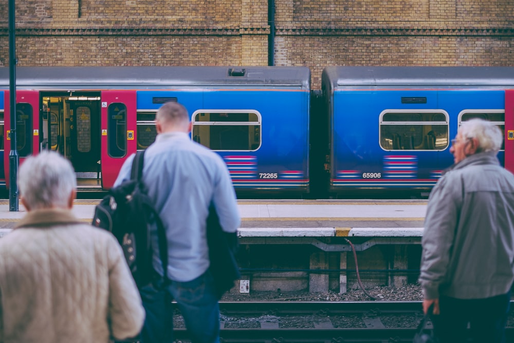 person in gray dress shirt standing in front of train rail