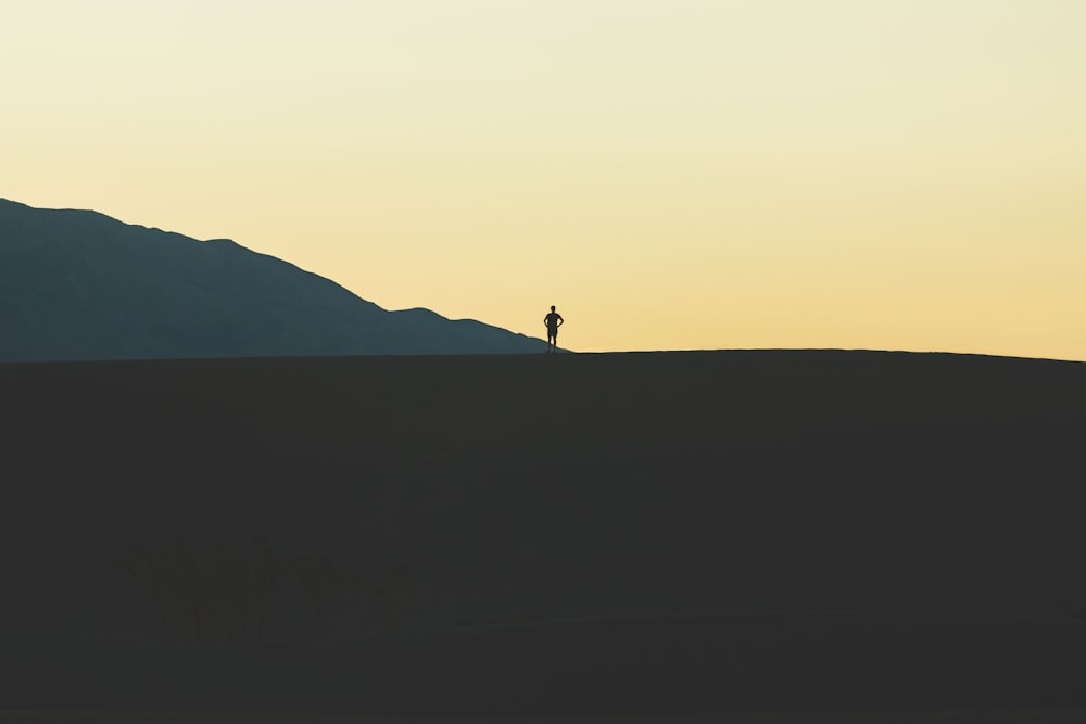 silhouette of person standing on mountain