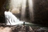 woman standing near river under gray sky during daytime