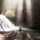 woman standing near river under gray sky during daytime