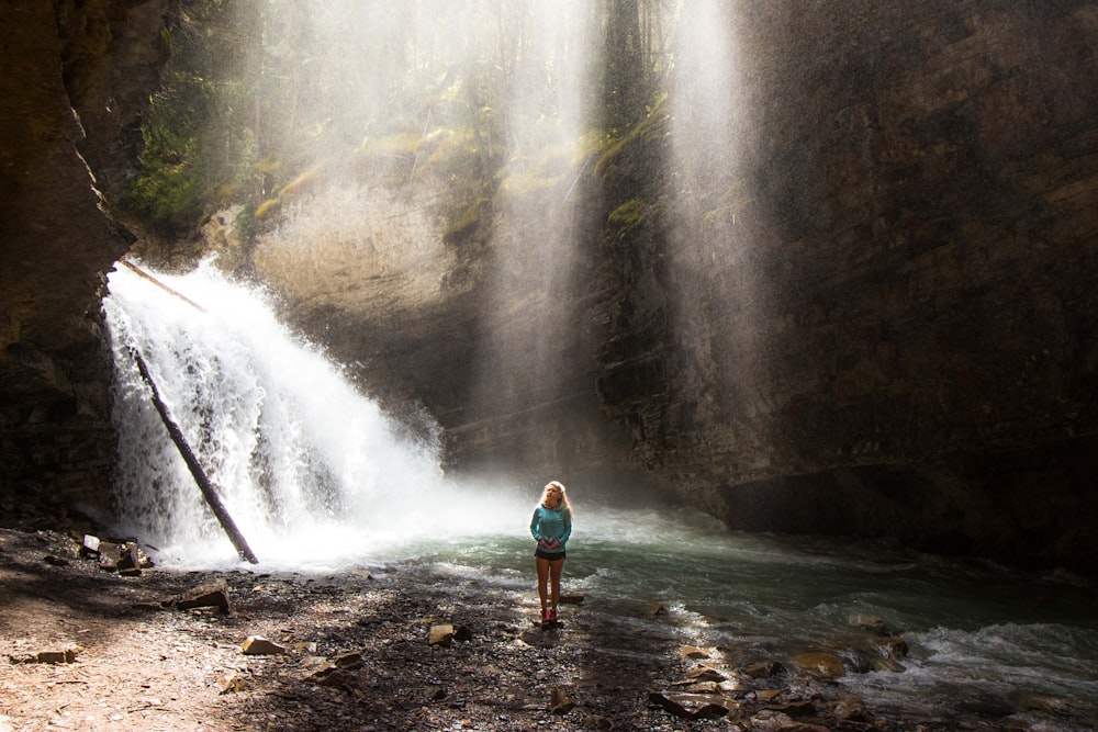 woman standing near river under gray sky during daytime