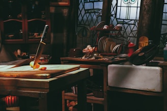 A rustic kitchen scene with gleaming artisanal chef knives arranged neatly on a wooden cutting board.