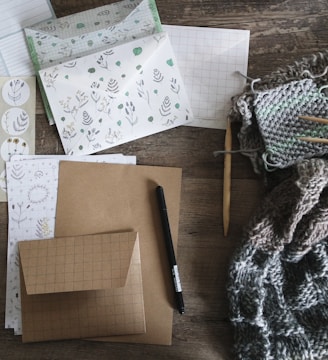 black pen beside envelop and knit scarf