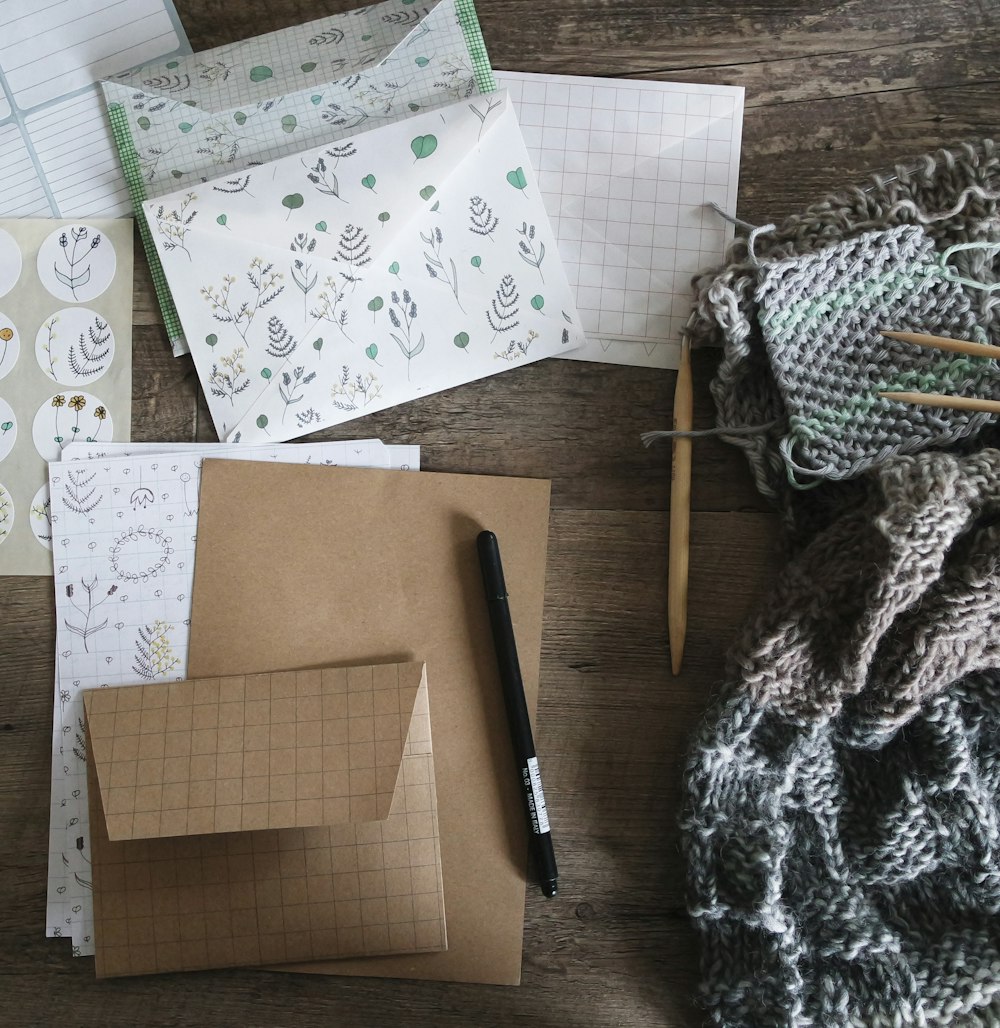 black pen beside envelop and knit scarf