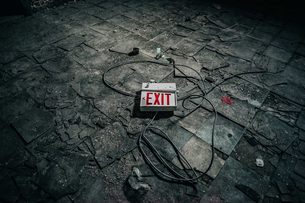 grey exit sign board on grey pavement