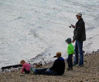 A happy family fishing together, with children safely using segurapez-covered hooks.