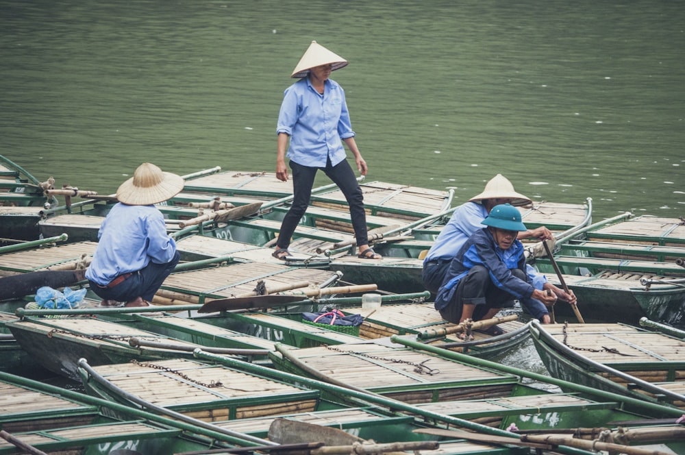 four men standing on boat during daytime