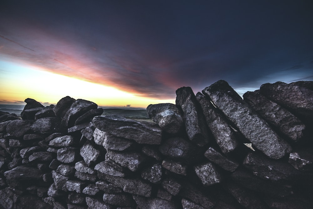 a stone wall with a sunset in the background