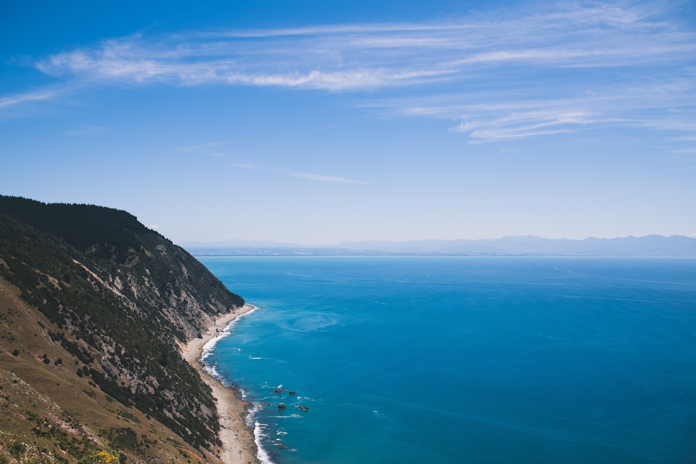 landscape photography of body of water beside mountains