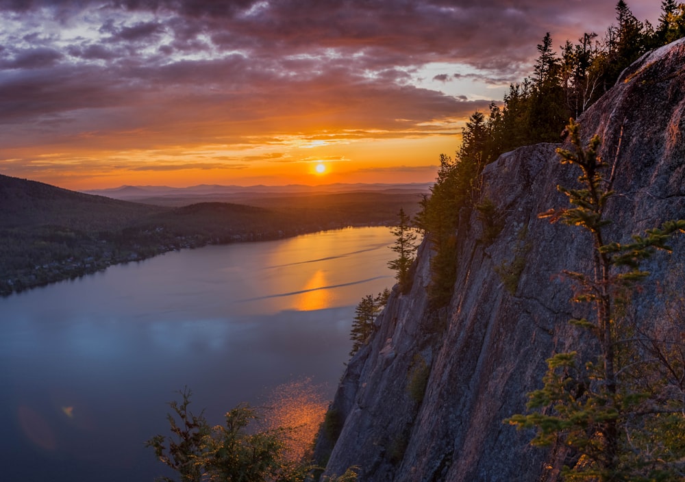 gray cliff near body of water during golden hour