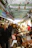A bustling Korean market scene showing street food vendors and customers interacting warmly.