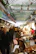 A bustling Korean market scene showing street food vendors and customers interacting warmly.