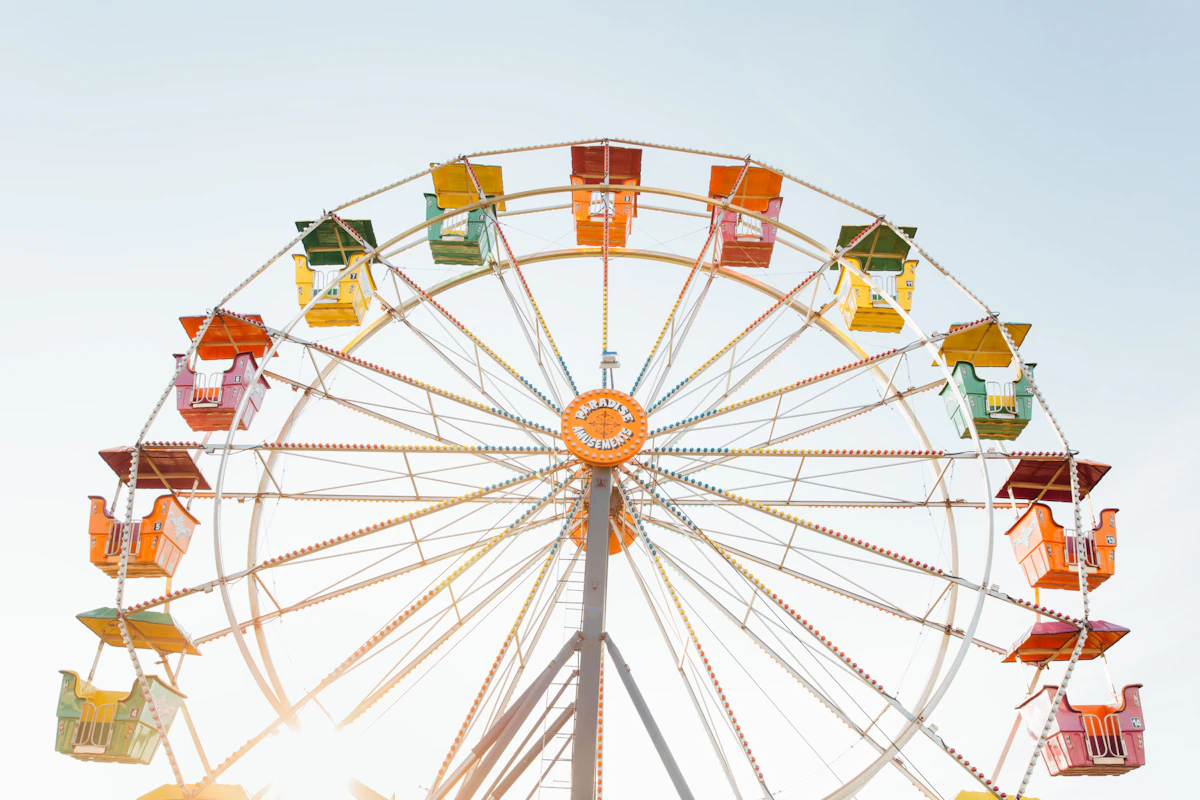 Yaz günü bir lunaparkta renkli dönme dolaba aşağıdan bakış