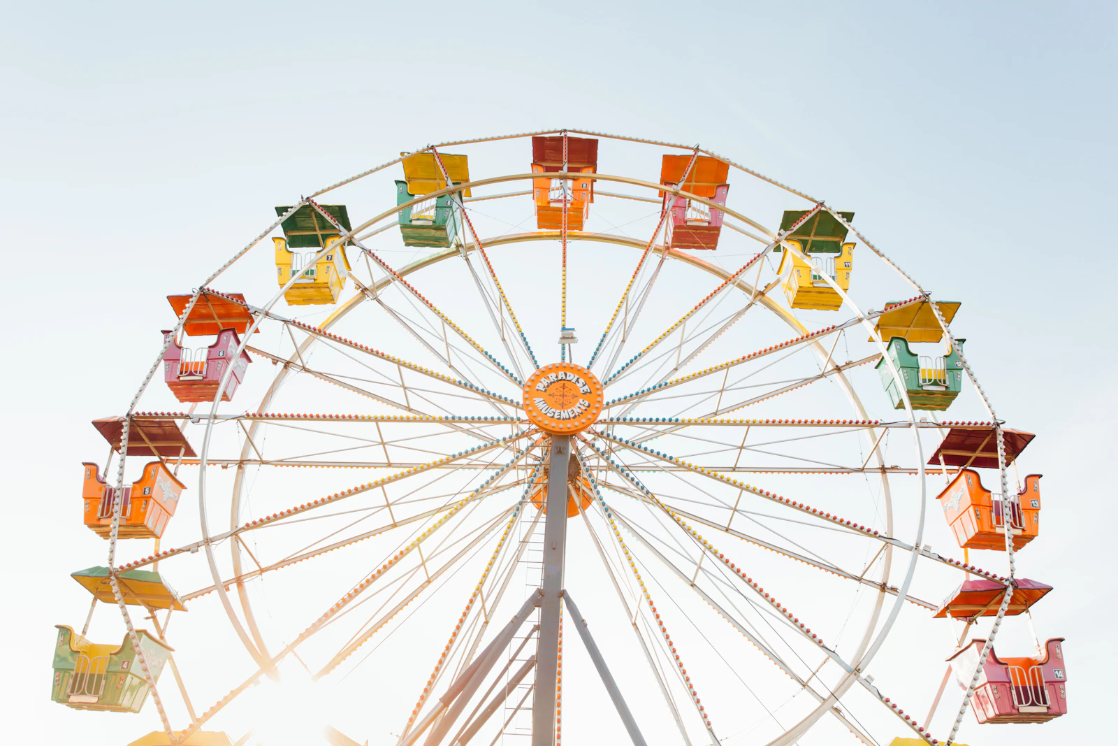 Grande roue colorée rouge, orange et jaune dans un parc d'attractions