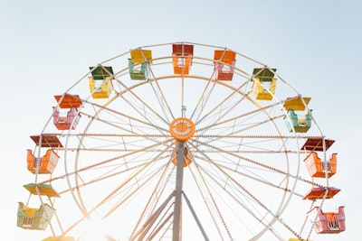 worm's eye view of red, orange, and yellow ferris wheel summer teams background