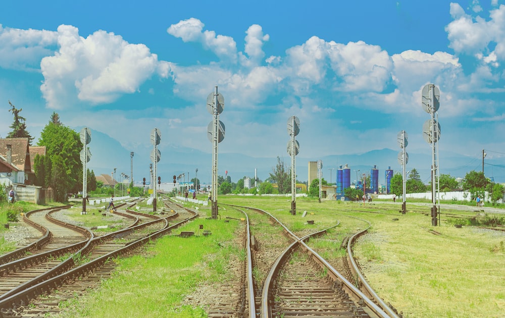 brown train rail under blue sky during daytime